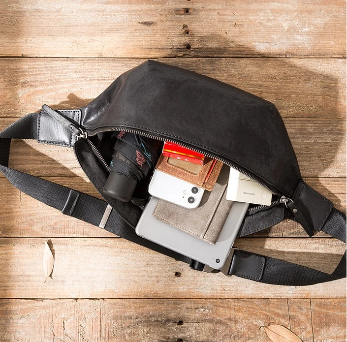 Premium cowhide messenger bag in black, featuring a spacious interior, adjustable shoulder strap, and sleek, minimalist design