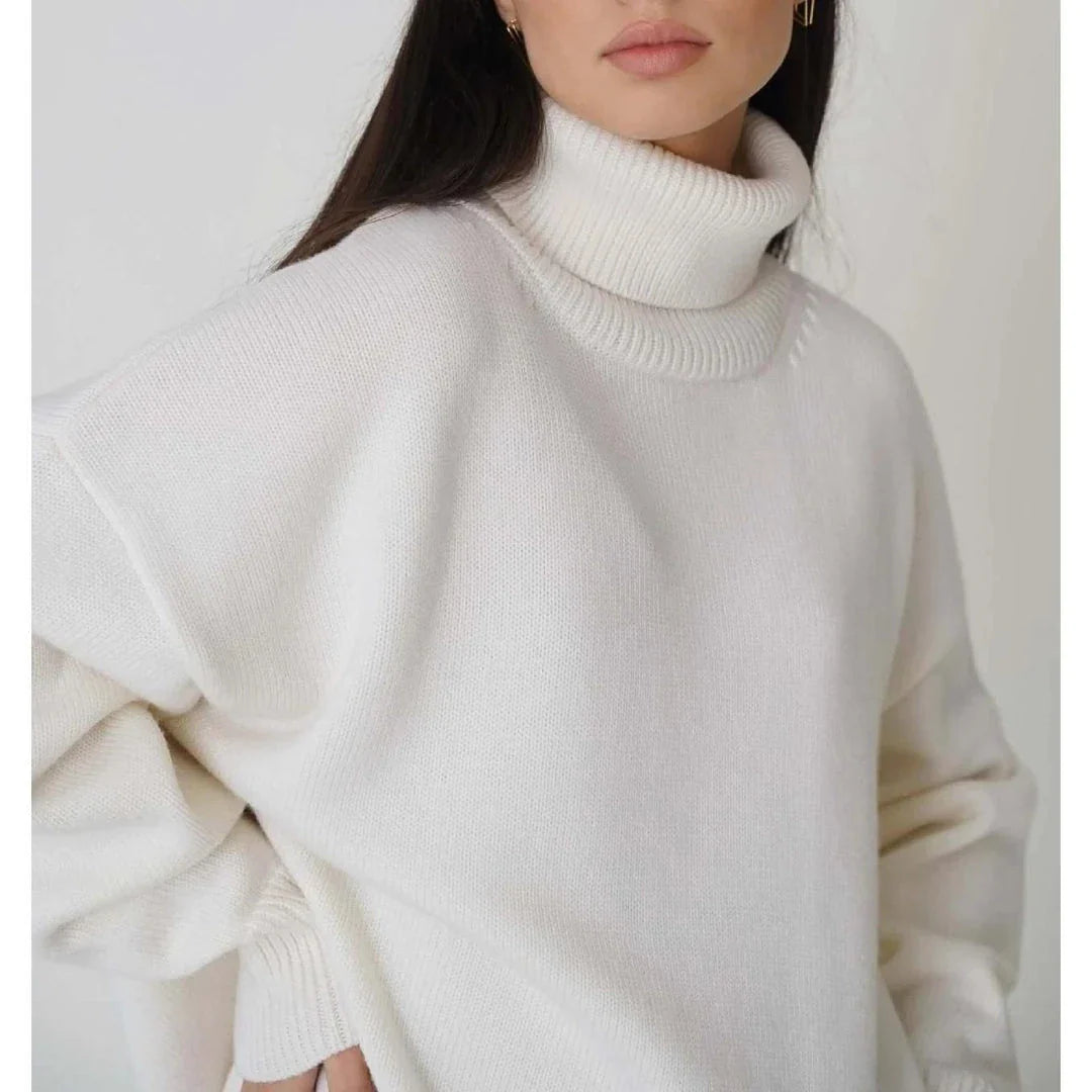 Cosy oversized knitted pullover in blue, featuring a classic turtleneck collar and drop-shoulder silhouette for maximum comfort and style.