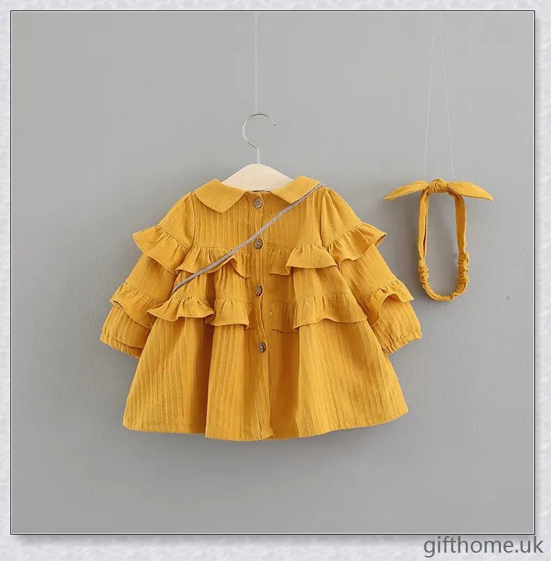 A beautiful summer dress for girls with a delicate floral pattern, long sleeves, and included accessories like a hair accessory and handbag