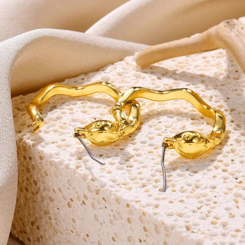 A pair of gold-toned stainless steel hoop earrings, showcasing a classic and sophisticated design