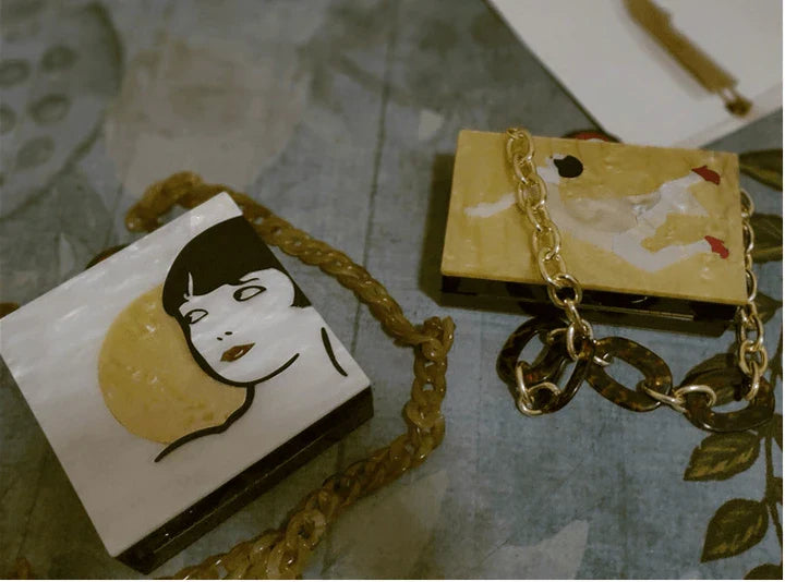 Antique hand-stitched acrylic crossbody bag in a vintage style with a yellow chain strap, perfect for evening events or everyday use.