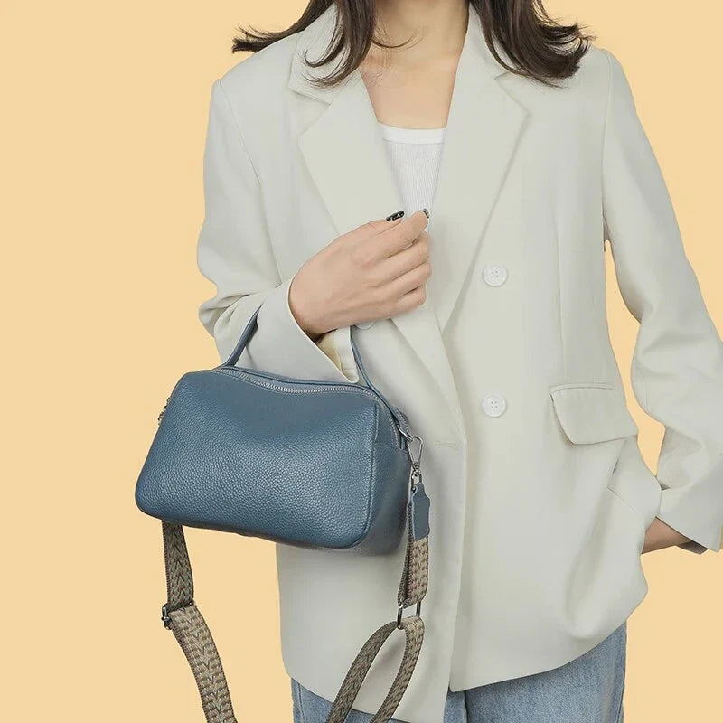 Luxurious genuine leather crossbody bag for women, featuring a soft polyester lining, dual phone pockets, and a compact, square design.