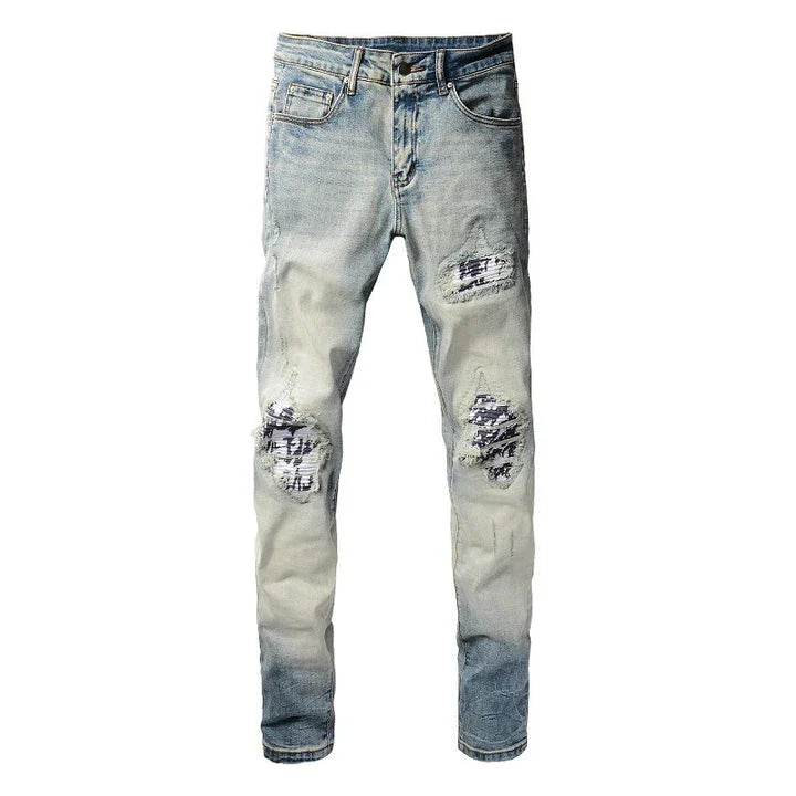 Stylish ripped denim jeans with a unique black and white patch design, perfect for British gentlemen