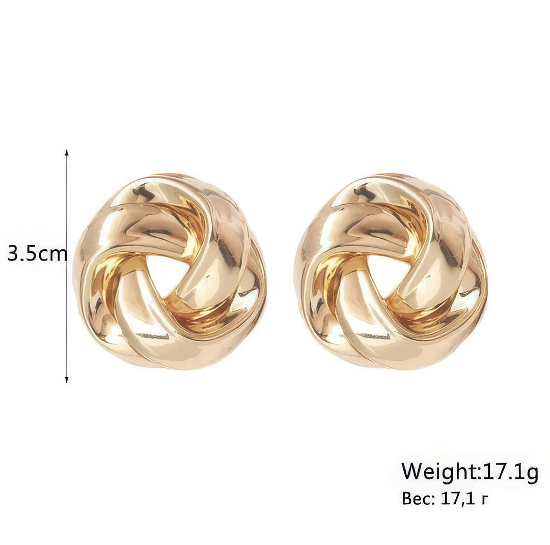 Pair of gold spiral drop earrings with an exaggerated, dramatic design for a bold, fashionable look