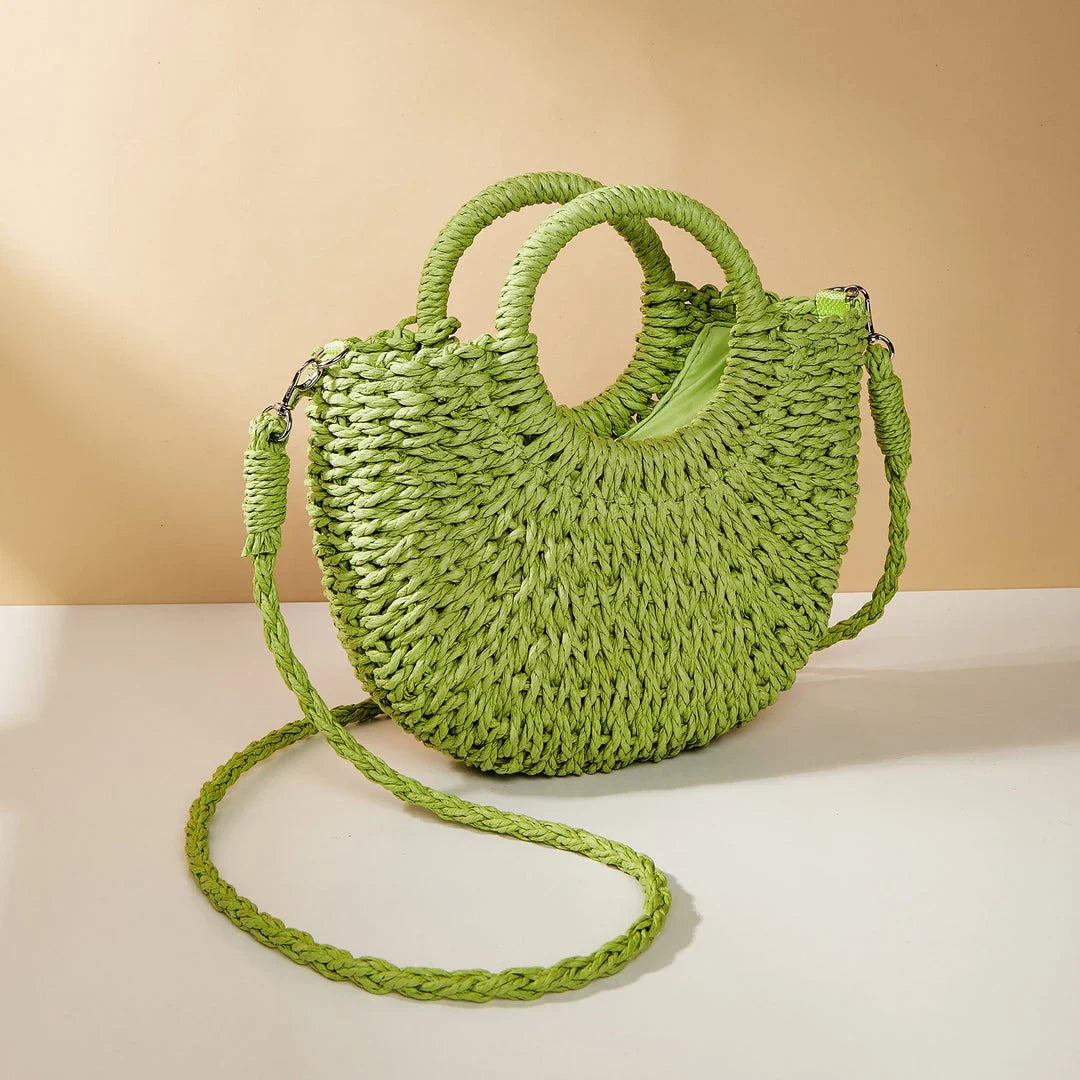 Stylish straw woven women's beach shoulder bag in a half-moon shape, featuring a cotton lining and string closure for a minimalist, bohemian-inspired look.