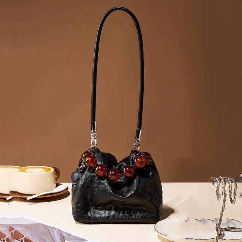 Premium leather crossbody bag with intricate beadwork, featuring a classic saddle shape and adjustable shoulder straps for versatile and secure everyday use.