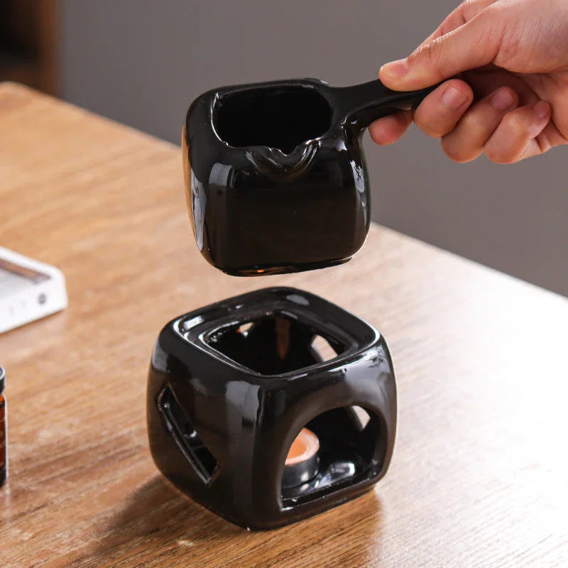 Elegant ceramic candle holder and tea warmer set in a classic square design with a wooden handle