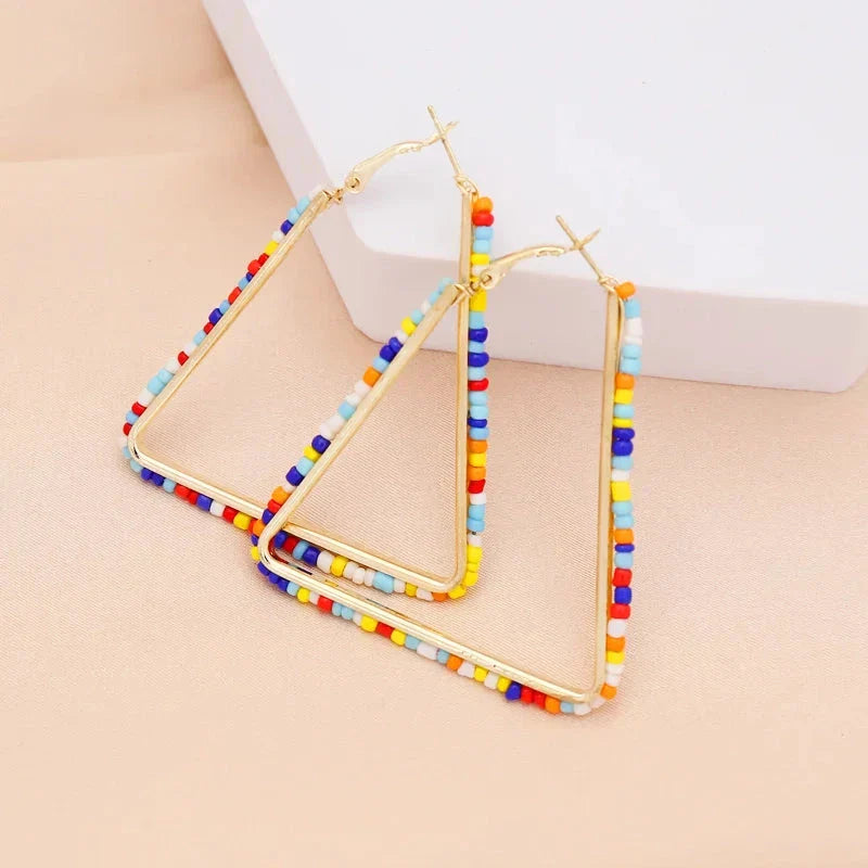 Colourful beaded triangle hoop earrings in gold metal with vibrant beadwork