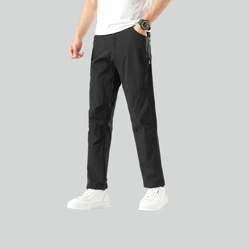 Weatherproof outdoor trousers for men in black, gray, and green colours with adjustable waistband and reinforced panels