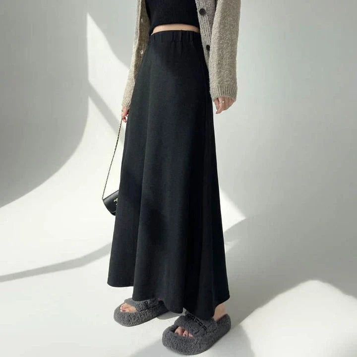 Elegant high-waist knitted skirt in black, showcasing a flattering A-line silhouette and ankle-length cut for the modern British woman.