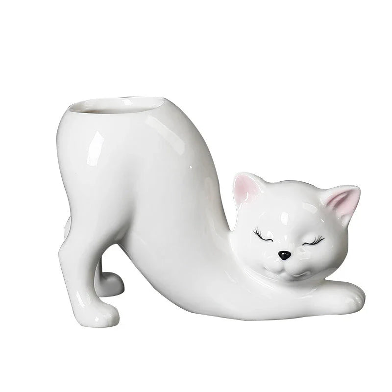 A white ceramic flower pot with a playful cartoon cat design and a functional tail element, perfect for desktops and small spaces.