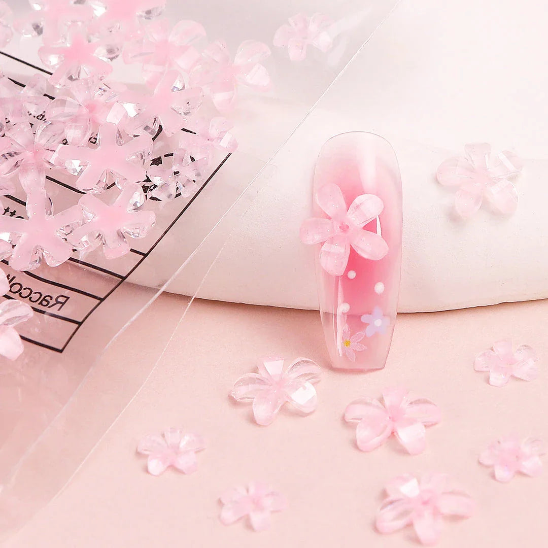 Elegant 3D flower nail charms in white and pink colours, featuring a transparent jelly finish and rhinestone accents for a stylish manicure