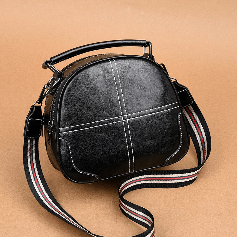 A stylish and versatile stitched shoulder bag in a classic brown colour, featuring a sleek oval shape and multiple interior compartments for organised storage.