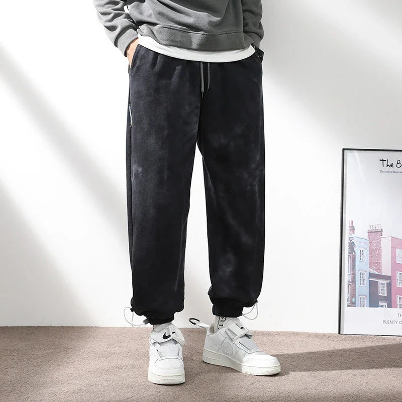 Stylish ankle-tied sweatpants in camouflage black, featuring an elasticated waistband, drawstring, and ankle ties for a relaxed yet refined look.