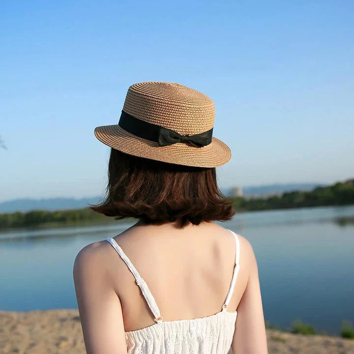 A classic summer Panama hat made from straw and paper, featuring a charming bow detail that adds a feminine touch.