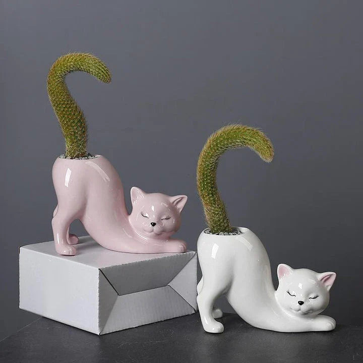 A white ceramic flower pot with a playful cartoon cat design and a functional tail element, perfect for desktops and small spaces.