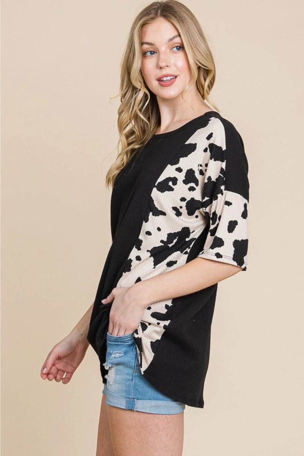 Stylish ribbed tee with playful cow print design, perfect for casual and smart-casual occasions.