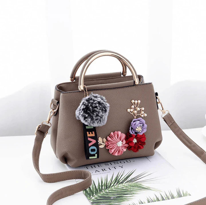 Elegant leather tote bag with delicate flower embellishments, perfect for modern British fashion