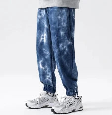 Stylish ankle-tied sweatpants in camouflage black, featuring an elasticated waistband, drawstring, and ankle ties for a relaxed yet refined look.
