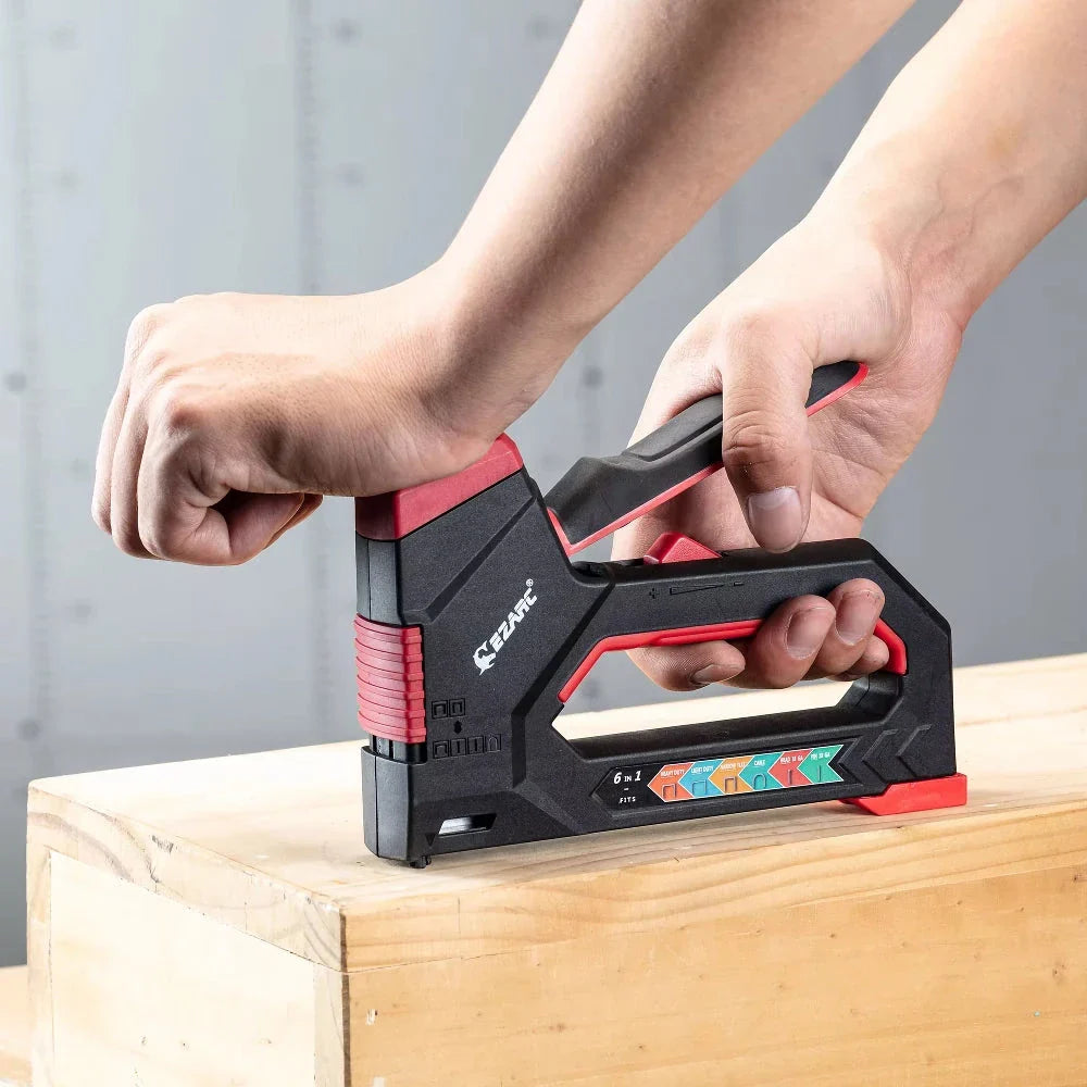 A heavy-duty manual staple gun with a black body and rubber grip, capable of driving multiple types of fasteners for a variety of DIY projects.