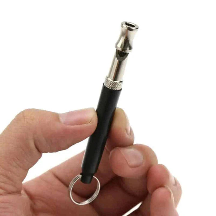 Compact ultrasonic dog training whistle in black and silver color, with a keyring loop for easy attachment