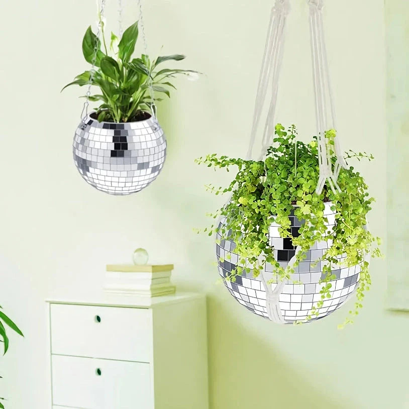 A sparkling silver disco ball hanging planter with reflective glass mirrors, adding a modern and stylish touch to any indoor or outdoor space.