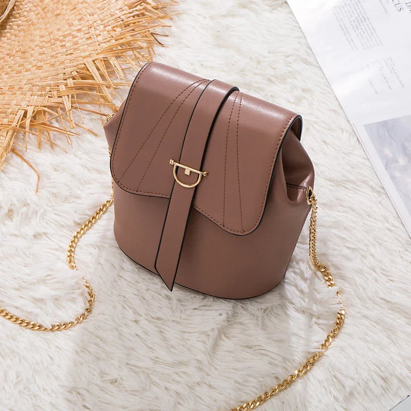 A large capacity chain bag with a classic bucket silhouette, crafted from premium leather-look material for sophisticated British style.