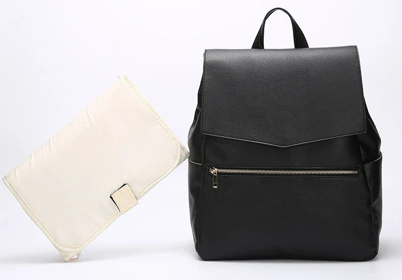 A stylish and practical PU leather mummy bag with a large capacity, multiple pockets, and included accessories like a changing pad and stroller hooks.