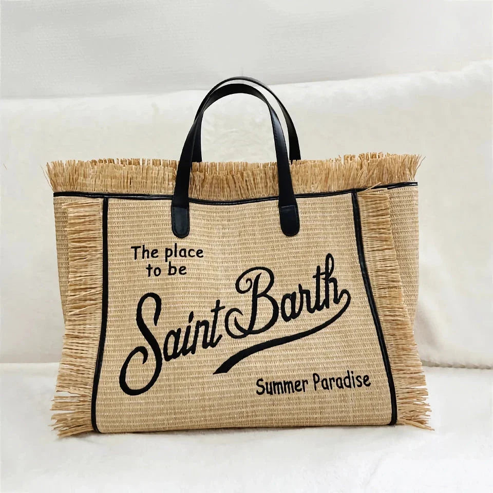 Stylish embroidered straw tote bag with playful tassels, perfect for summer outings and beach adventures.