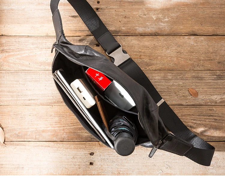 Premium cowhide messenger bag in black, featuring a spacious interior, adjustable shoulder strap, and sleek, minimalist design