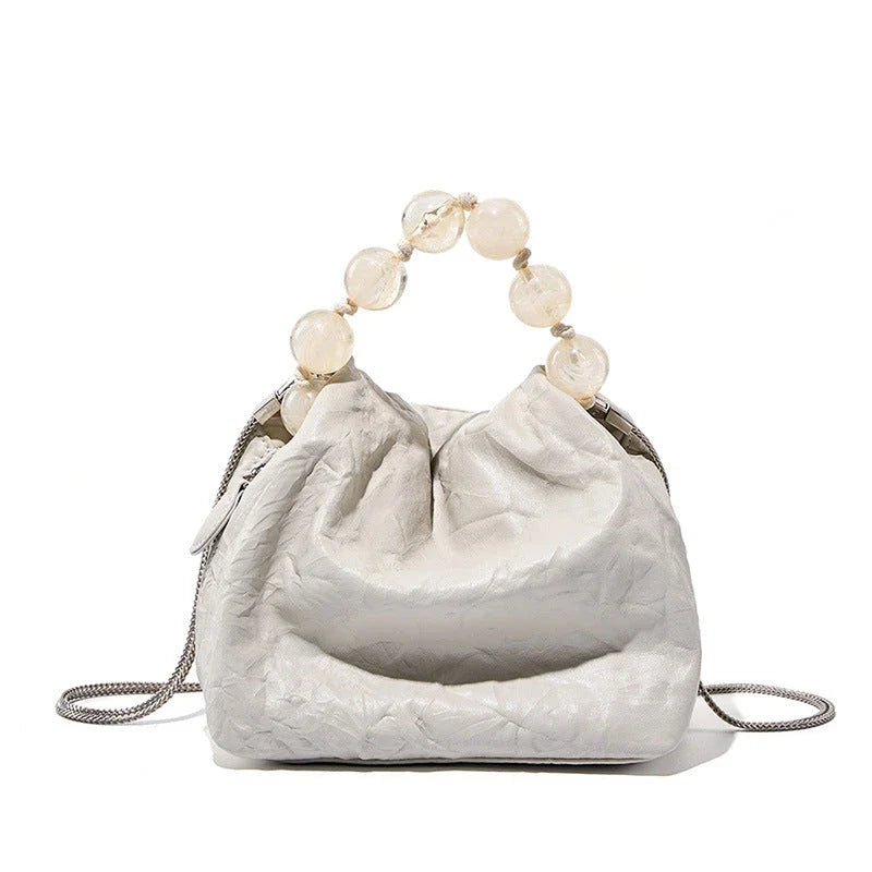 Premium leather crossbody bag with intricate beadwork, featuring a classic saddle shape and adjustable shoulder straps for versatile and secure everyday use.