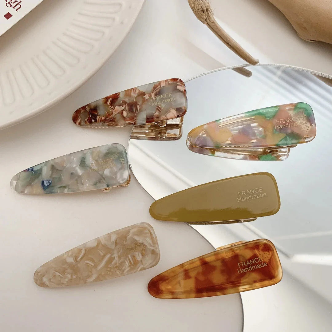 Two marble-patterned hair clips in a contemporary geometric design, made from high-quality acetate and acrylic materials.