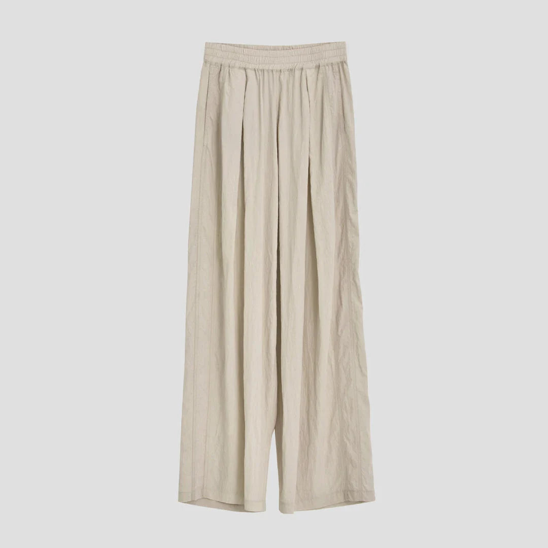 Pleated wide-leg high-waisted trousers in a herringbone plaid pattern, featuring a flattering silhouette and comfortable cotton-linen blend