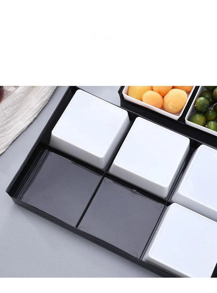 Premium British plastic snack trays in a variety of colours, including clear, white, and grey, with a black, white, or natural wood pallet for storage and display.