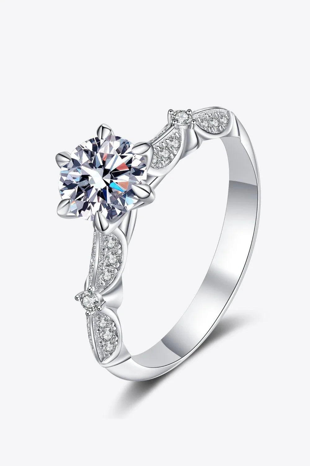 Closeup of an elegant sterling silver ring with a sparkling moissanite centre stone in a 6-prong setting