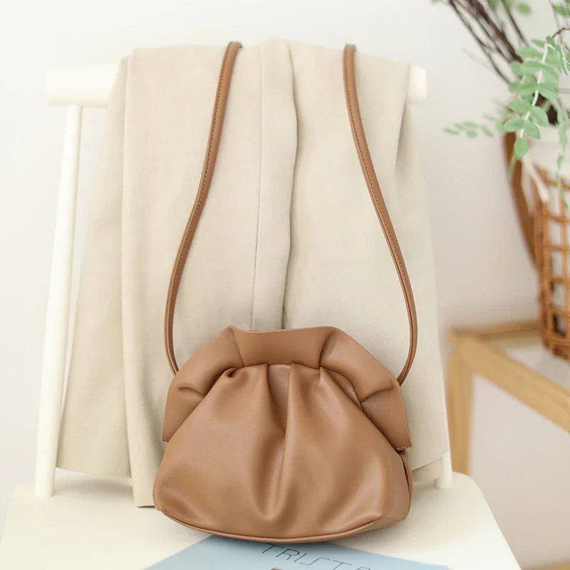 Stylish retro dumpling bag in premium PU material with one-shoulder design and adjustable strap, available in classic British colours