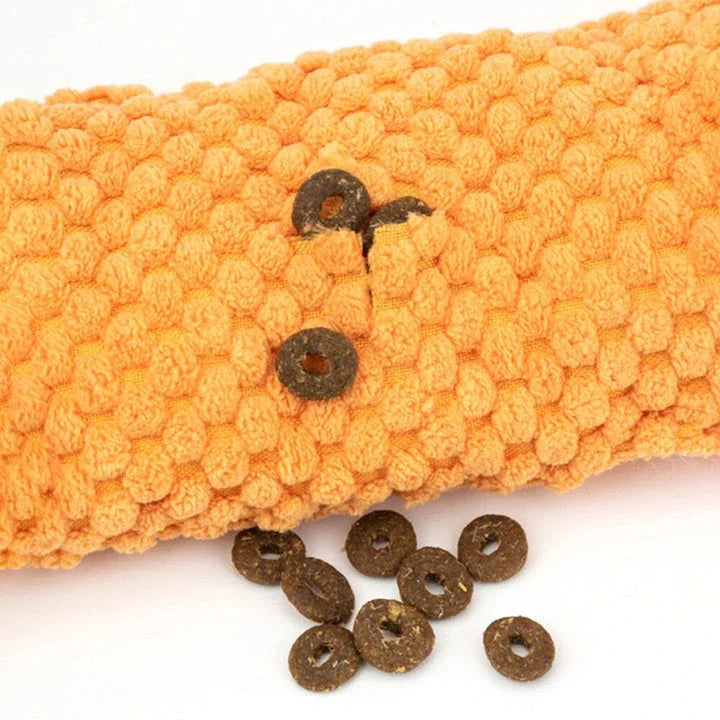 A plush snail-shaped snuffle mat toy with hidden treat pockets, designed to stimulate a dog's natural foraging instincts.