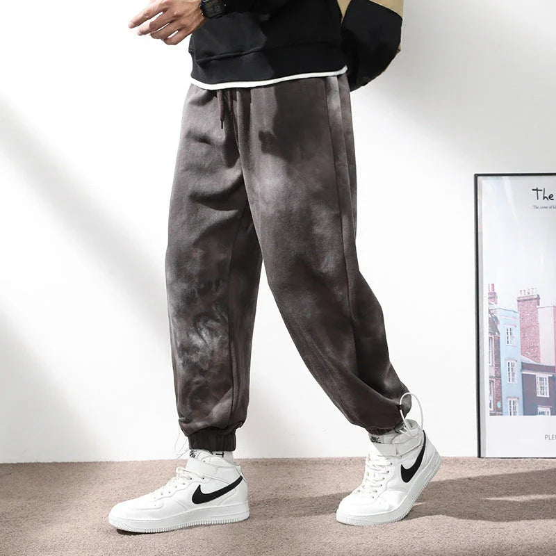 Stylish ankle-tied sweatpants in camouflage black, featuring an elasticated waistband, drawstring, and ankle ties for a relaxed yet refined look.