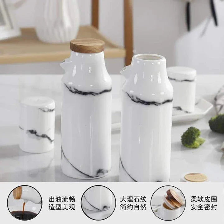 Ceramic salt and pepper shaker set with oil bottle in light grey porcelain finish, featuring minimalist design and easy-grip handles