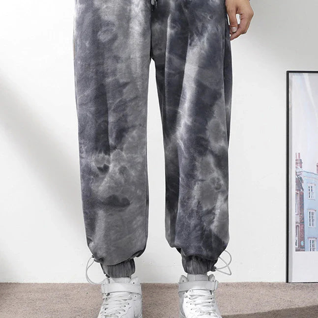 Stylish ankle-tied sweatpants in camouflage black, featuring an elasticated waistband, drawstring, and ankle ties for a relaxed yet refined look.