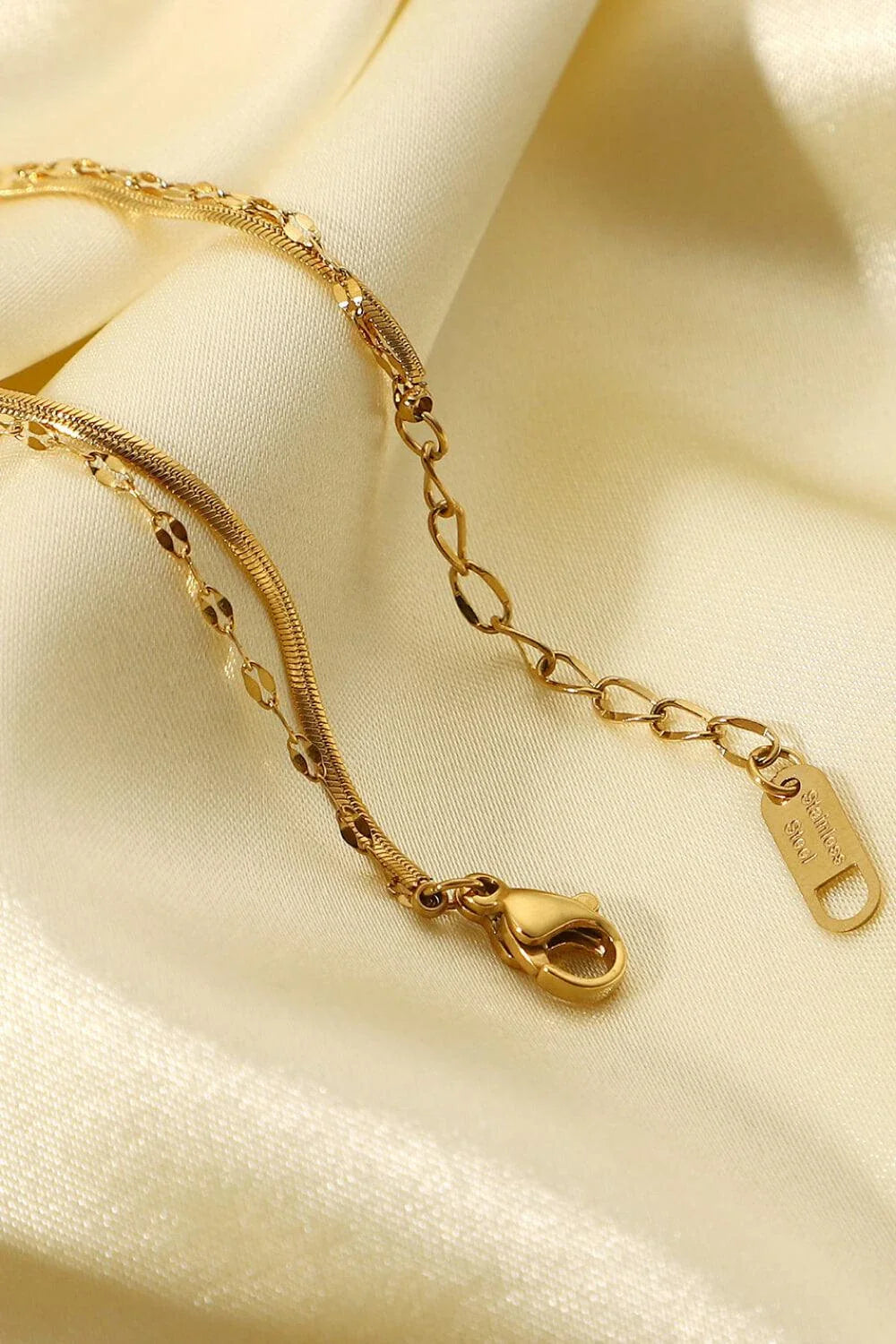 Close-up of a gold-coloured double-layered bracelet with sparkling rhinestones, on a white background.