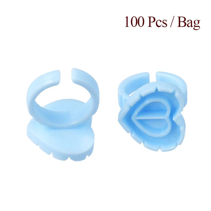 Heart-shaped disposable eyelash glue rings in blue, pink, and white colours