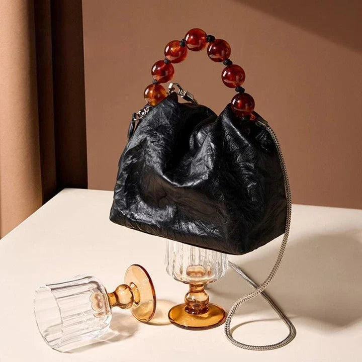 Premium leather crossbody bag with intricate beadwork, featuring a classic saddle shape and adjustable shoulder straps for versatile and secure everyday use.