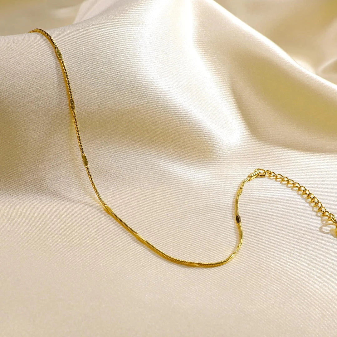 Elegant gold stainless steel minimalist anklet with delicate charm, adjustable length, and durable construction