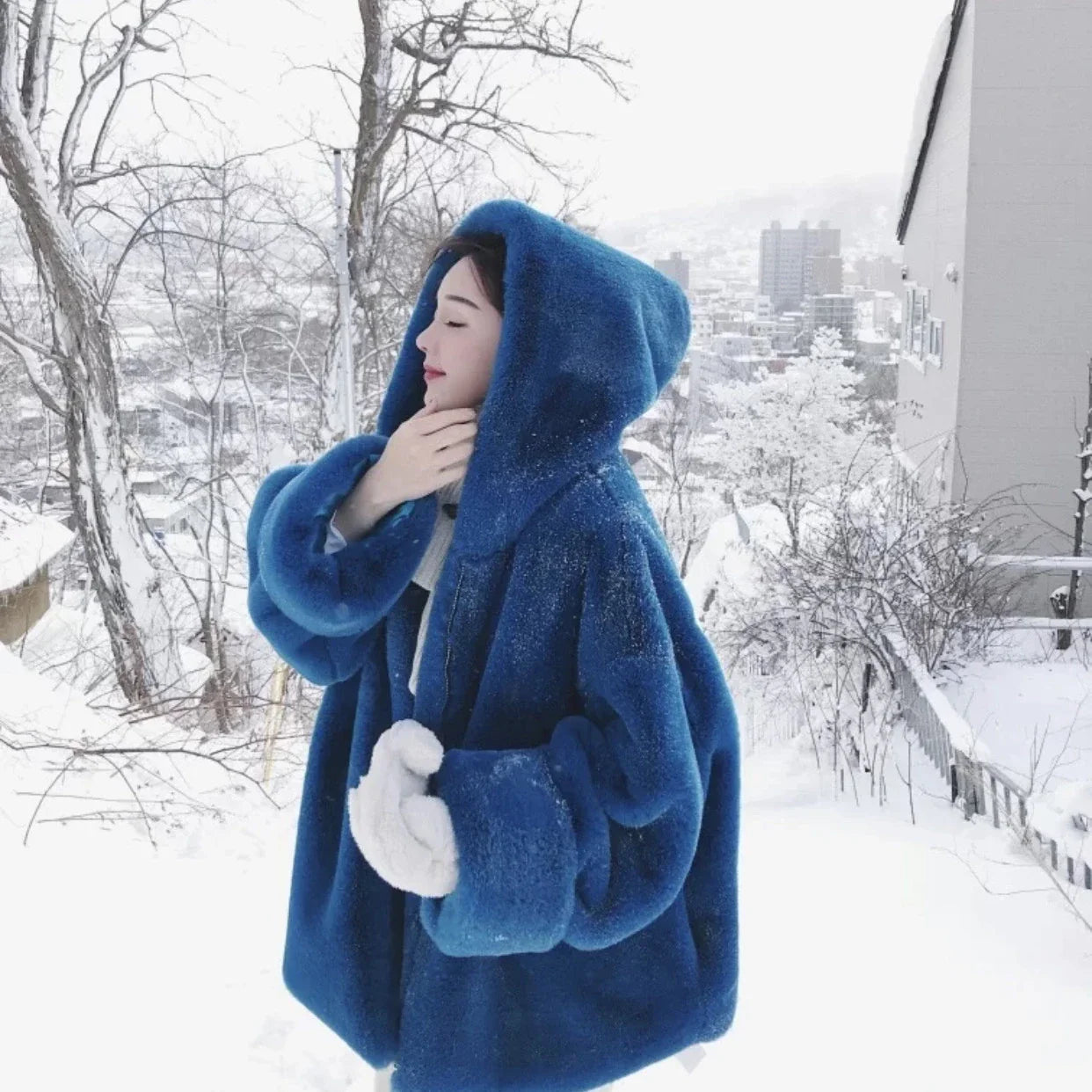 A stylish navy blue faux fur rabbit coat with a hooded design and medium length, perfect for staying warm and fashionable in the UK.