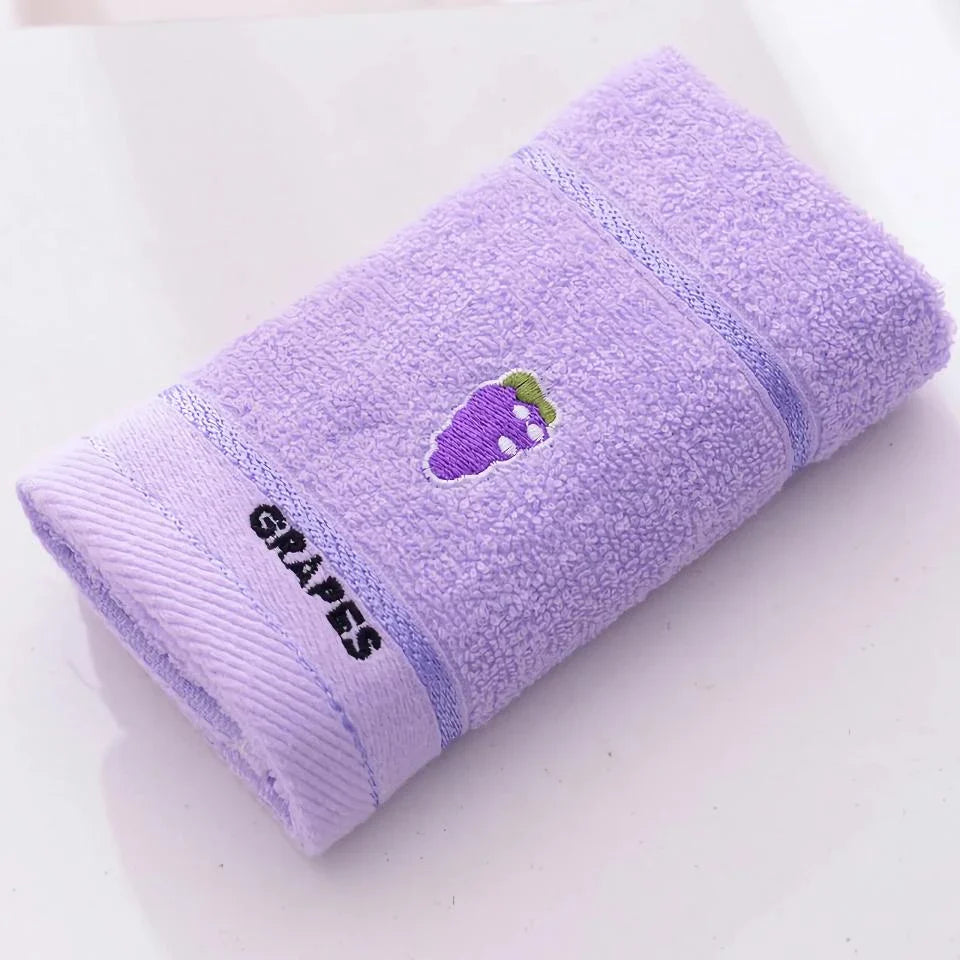 Soft cotton baby bath towel with adorable cartoon fruit face designs in pink