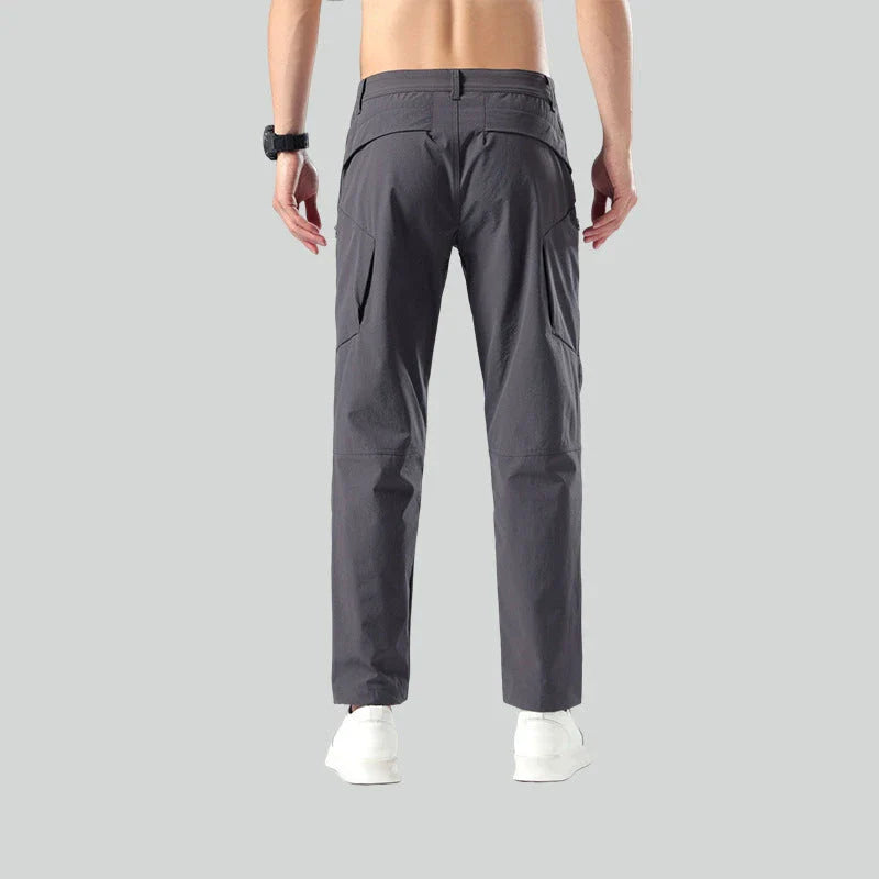 Weatherproof outdoor trousers for men in black, gray, and green colours with adjustable waistband and reinforced panels