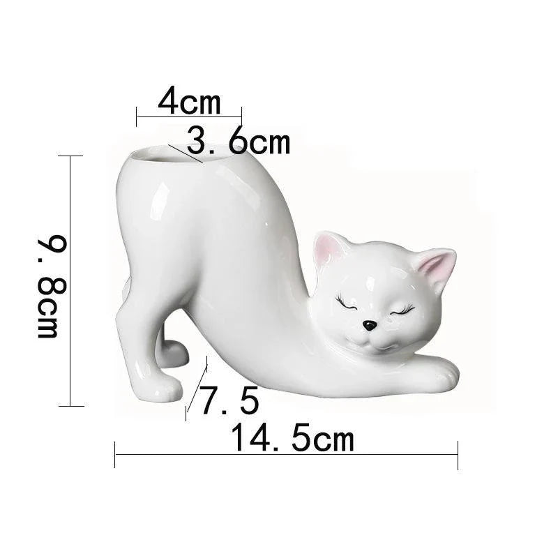 A white ceramic flower pot with a playful cartoon cat design and a functional tail element, perfect for desktops and small spaces.