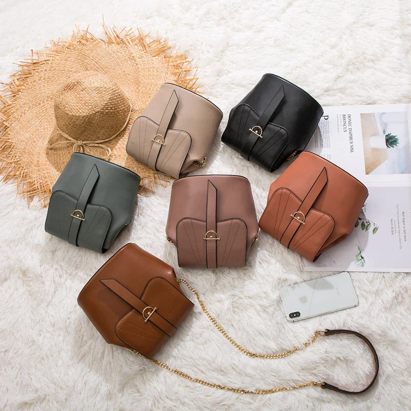 A large capacity chain bag with a classic bucket silhouette, crafted from premium leather-look material for sophisticated British style.