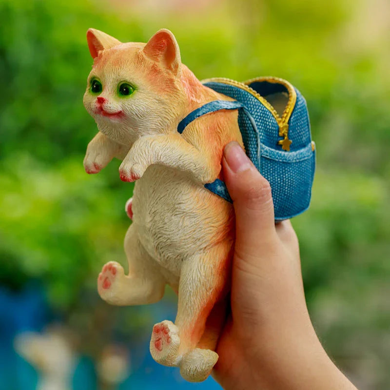 A charming resin cat figurine wearing a stylish backpack, serving as a unique garden decoration and practical storage solution.